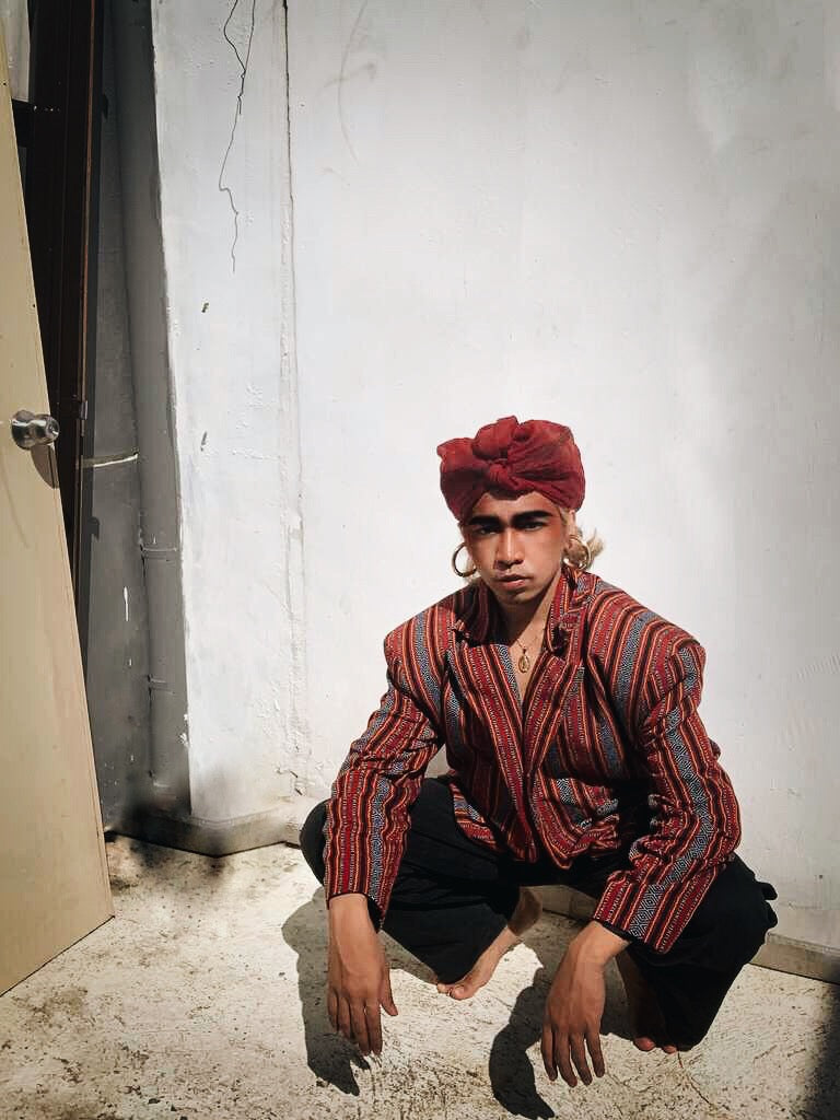 VINTA Unisex Oversized Ifugao Jacket, male model is squatting, styled with red headscarf and gold hoop earrings